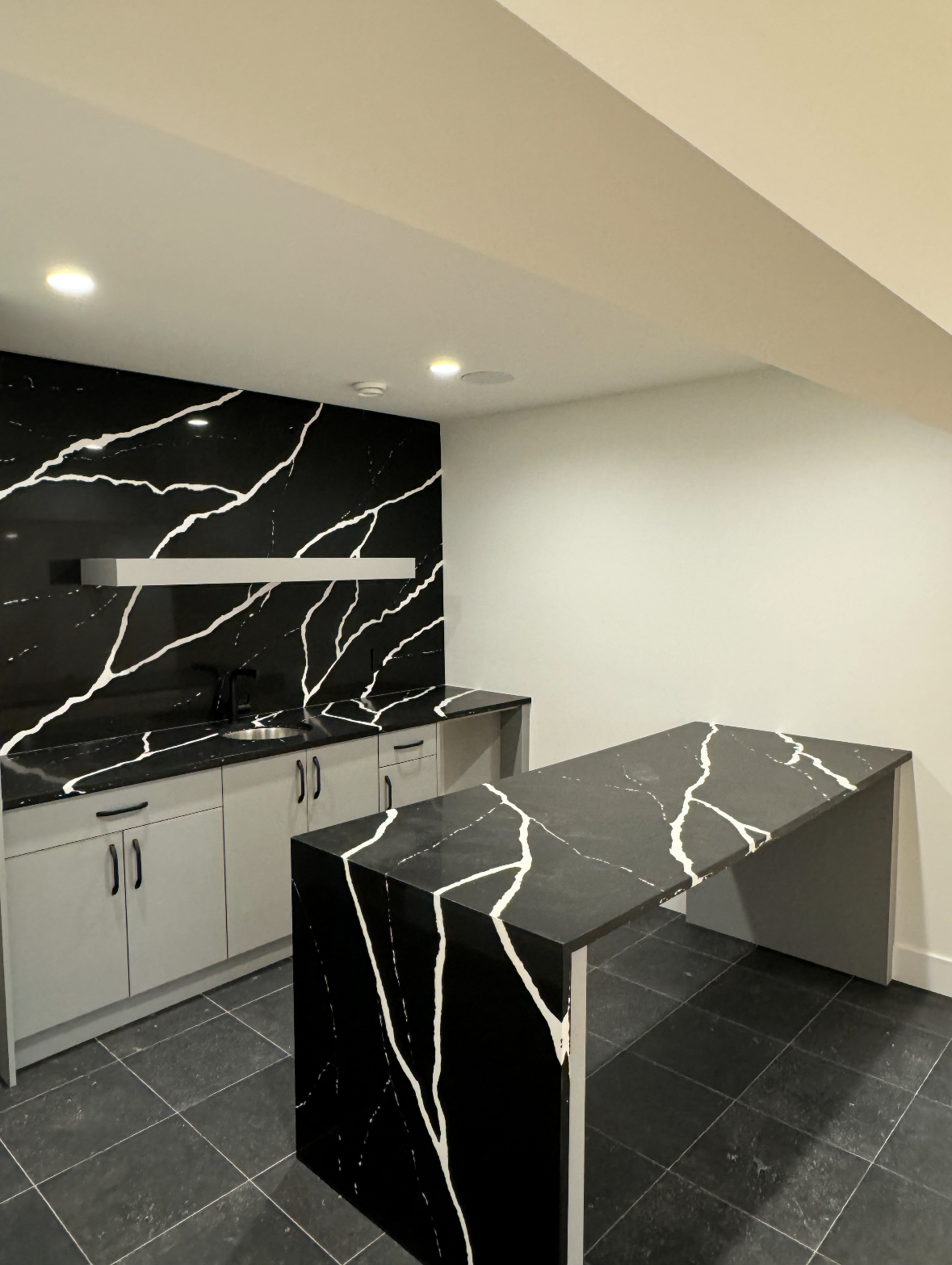 Finished basement wet bar with quartz waterfall